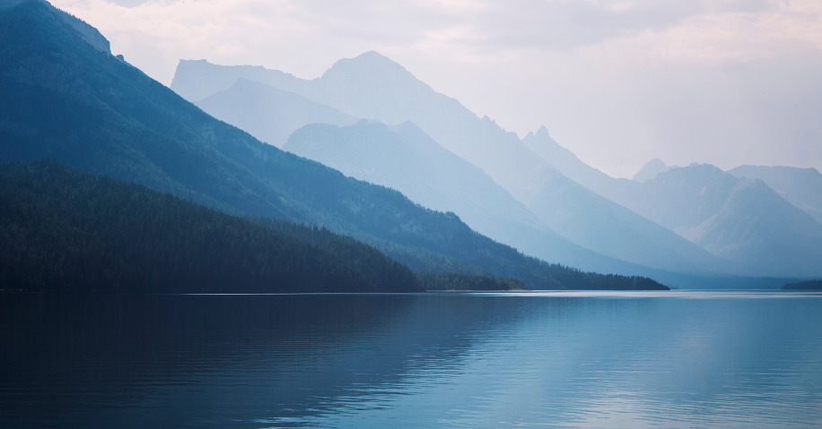 A calm lake surrounded by mountains.