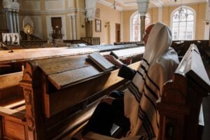 A man sitting on a bench inside the synagogue