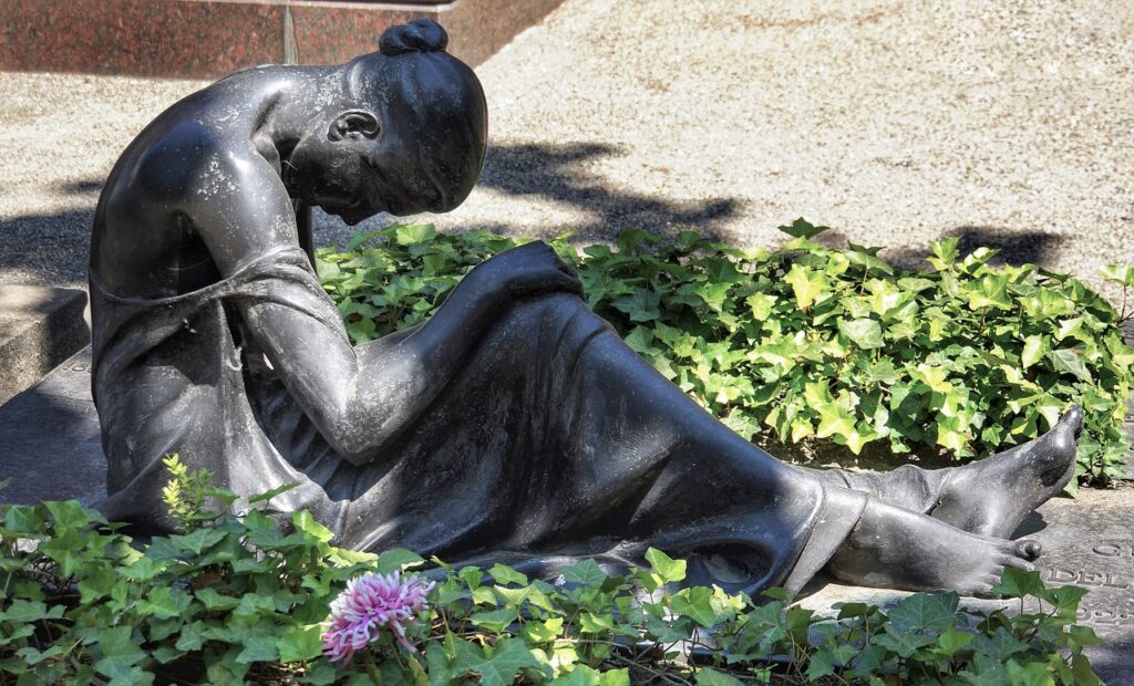 A sculpture of a woman lying on the ground, grieving for someone