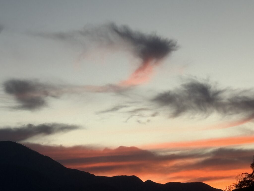 Colorful sunset behind dark mountains.