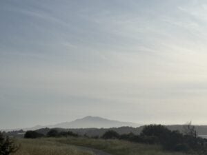 A hazy sky stretches over distant hills and a quiet landscape