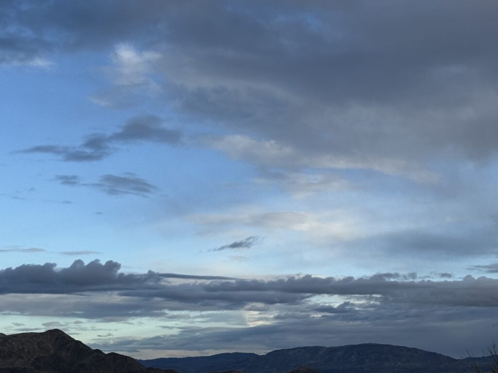 A dramatic sky opens over the ocean and distant coastline