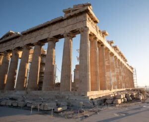 The Parthenon in Athens, with ancient stone columns illuminated by warm sunlight.